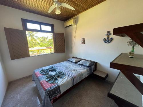 a bedroom with a bed and a window at Residencial e Pousada Ilhéus in Ilhéus