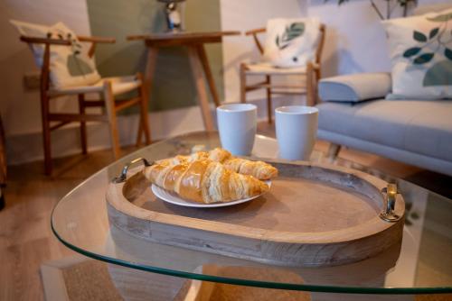 a glass table with a plate of croissants on a table at Corner House Studio in Skipton