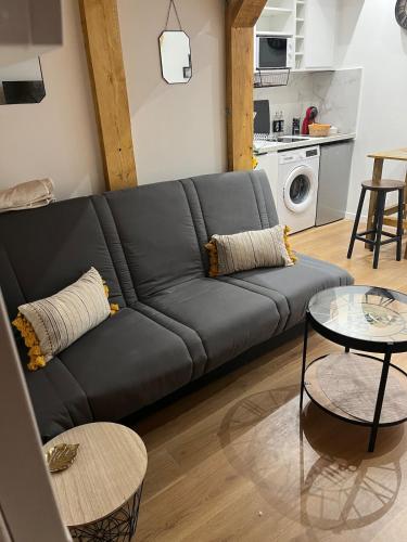 - un canapé noir dans le salon avec une cuisine dans l'établissement Nice Cosy, à Nice