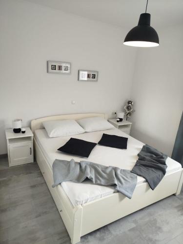 a bedroom with a white bed with black pillows at Anna Maris apartment in Rab
