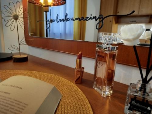 a table with a book and a bottle of perfume at Anna Maris apartment in Rab