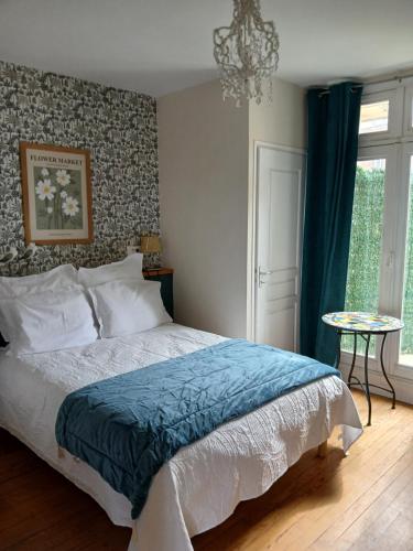 a bedroom with a bed with a blue blanket and a window at Voiles et Terrasses by Corinne Résidence face au port in Le Tréport