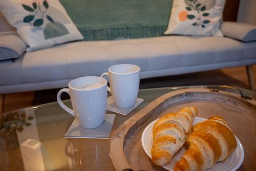 a tray with croissants and two cups on a table at Corner House Studio in Skipton