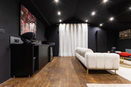 a living room with a white couch and a table at SecretRoom - Luxe, Balnéo et évasion -Arnage in Arnage