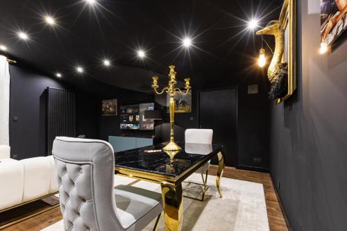 a dining room with a glass table and white chairs at SecretRoom - Luxe, Balnéo et évasion -Arnage in Arnage