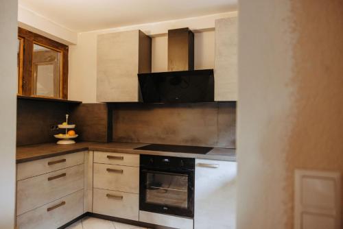 a kitchen with wooden cabinets and a stove top oven at Außerhalb2 - Chalet Wassermühle in Weisel