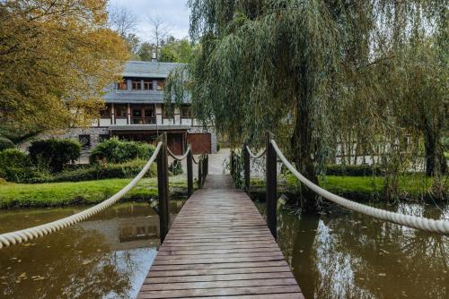 a wooden bridge over a river with a house at Außerhalb2 - Chalet Wassermühle in Weisel