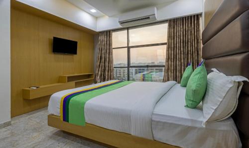 Un dormitorio con una cama grande y una ventana. en Treebo Eden Park, Ahmedabad, en Ahmedabad