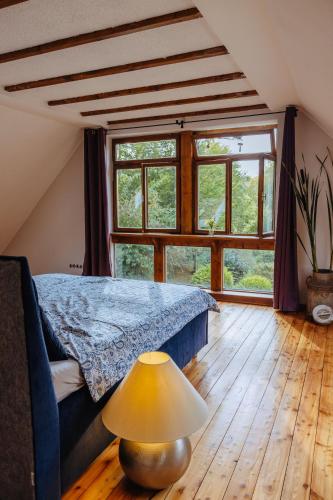 a bedroom with a bed and a lamp on a wooden floor at Außerhalb2 - Chalet Wassermühle in Weisel