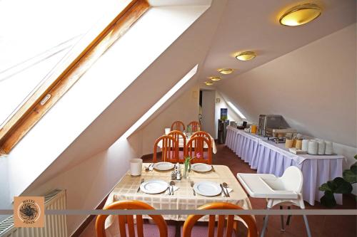 - une salle à manger avec une table et des chaises dans l'établissement Hotel Főnix, à Pécs