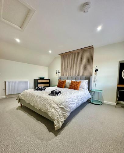 a large bedroom with a large bed with orange pillows at Cozy Cottage Retreat in Portsoy