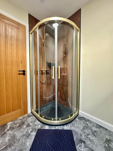 a bathroom with a shower with a glass door at Cozy Cottage Retreat in Portsoy