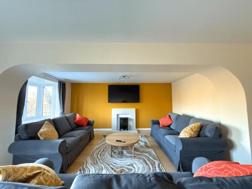 a living room with two couches and a table at Stunning 4 BR Townhouse for 8 With Free Parking in Dore