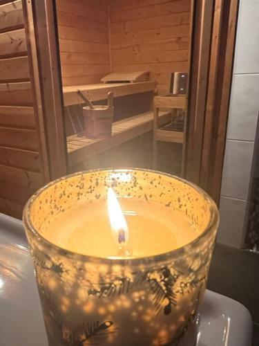 a candle in a bowl sitting on a table at Le Fôret - Cergnat in Le Sépey