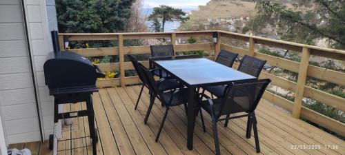 a table and chairs on a deck with a grill at Maison avec vue sur mer in Saint-Martin-Plage