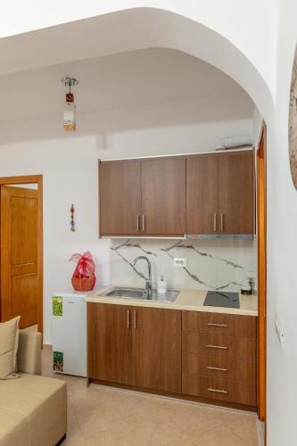 a kitchen with a sink and wooden cabinets at Aldi's Guesthouse in Çukë