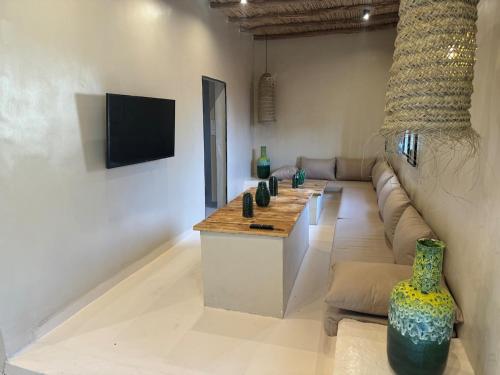 a living room with a couch and a table with vases at Simple Moroccan Rural Getaway in Tama ou Ennza
