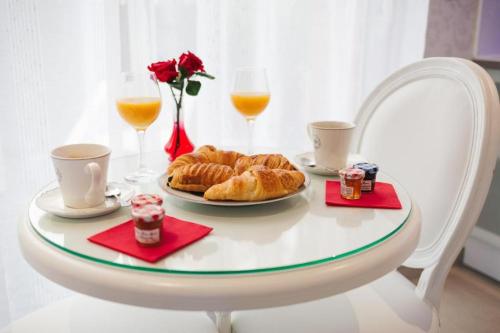 een tafel met croissants en glazen sinaasappelsap bij L'Etoilé VIP AVEC JACUZZI in Troyes