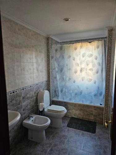 a bathroom with a toilet and a tub and a sink at El pisito de iker in Mondariz