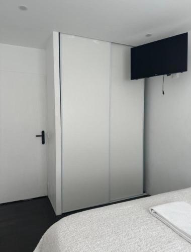 - une chambre avec une porte blanche coulissante à côté d'un lit dans l'établissement Appartement 3 pièces, dans résidence privée sécurisée et parking gratuit,a 9 min centre ville, à Nice
