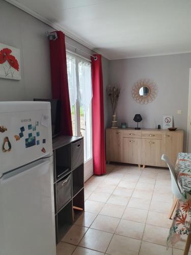 a kitchen with a white refrigerator and a table at La petite maison in Aunac