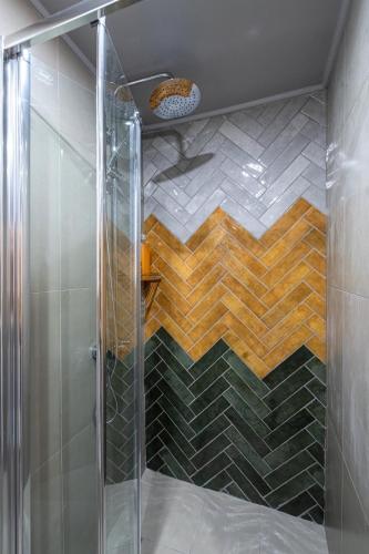 a shower with a glass door in a bathroom at Cozy Home in Karpenisi