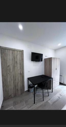a room with a table and a tv on a wall at Habitación turística en Irún in Irún