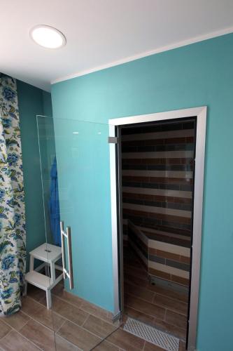 a bathroom with a blue wall and a glass shower at Villa Diana - Pesaro mare e cultura - intera struttura con piscina in Mombaroccio