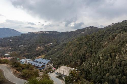 arial view of a mountain with a house and a road at Treebo Lords Garden Glory in Shimla
