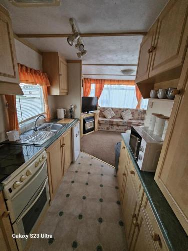 an rv kitchen with a sink and a stove at Beachside, Family-friendly, WiFi, 6 berth caravans in Ingoldmells