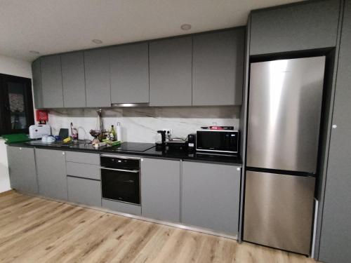a kitchen with stainless steel appliances and a refrigerator at Casa do Cabecinho in Pampilhosa da Serra