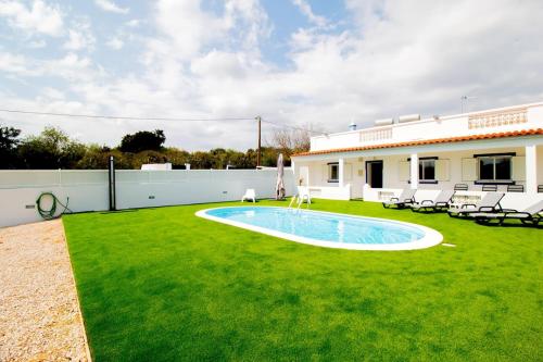 een tuin met een zwembad en een huis bij Villa Azul in Boliqueime