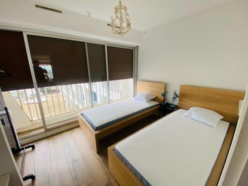 une chambre avec deux lits et une grande fenêtre dans l'établissement Duplex 2 bedrooms, harbor and sea view, center, wifi, à La Grande Motte
