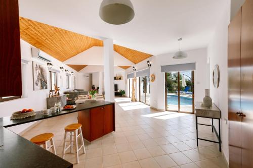 an open kitchen and living room with a pool at Dream Villa in Tala with Private Pool, Sea & Mountain Views & Garden Retreat in Paphos