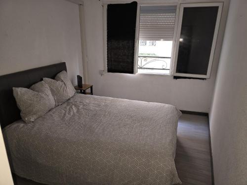 a bedroom with a white bed with a window at gite atoma in Rivesaltes