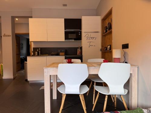 - une cuisine avec une table en bois et des chaises blanches dans l'établissement New Ski Apt in Three Valleys - L'Écrin, à Brides-les-Bains