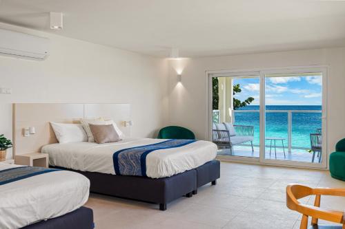 a bedroom with two beds and a view of the ocean at Boutique Hotel Bougainvillea in Kralendijk