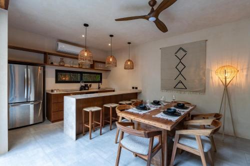 a kitchen with a table and chairs and a refrigerator at Moonstone - Villa with private pool and 24hrs security & Beach club access in Tulum