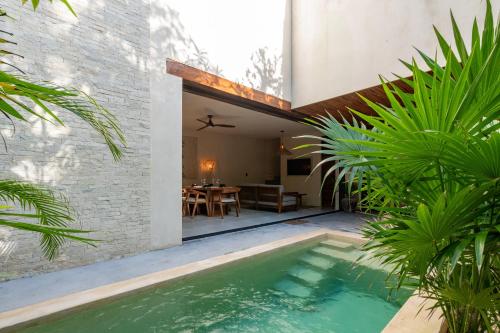 a pool in the backyard of a house with plants at Moonstone - Villa with private pool and 24hrs security & Beach club access in Tulum