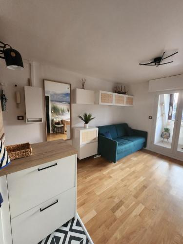 un salon avec un canapé bleu dans une pièce dans l'établissement Appartement Riva Bella 2 pièces à 200 m de la mer, à Ouistreham