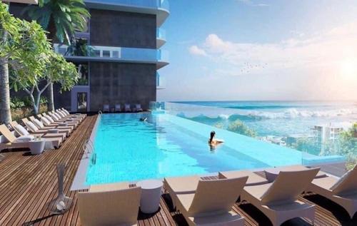 a woman in a swimming pool next to a building at Condotel CSJ Vũng Tàu - Apartment Luxury CSJ Vung Tau in Vung Tau