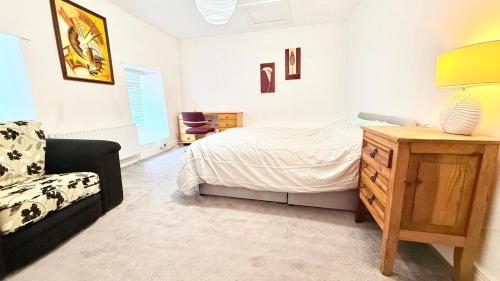 a bedroom with a bed and a chair in it at East End Drimoleague in Mutton Bridge