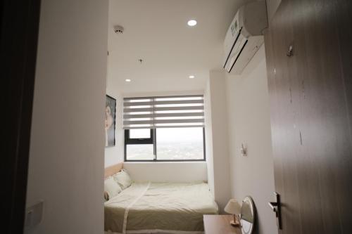 une petite pièce avec un lit et une fenêtre dans l'établissement Namihomestay Nera Garden Hue Pool and Gym Free, à Thôn Văn Dương