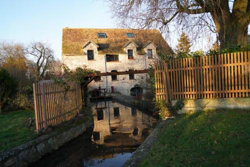 an old house with a bridge over a canal at Le Moulin de Dannemarie in Dannemarie