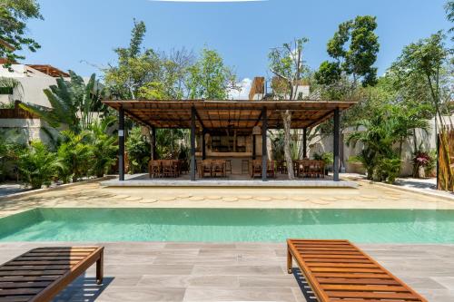 a swimming pool with a gazebo next to a house at Moonstone - Villa with private pool and 24hrs security & Beach club access in Tulum