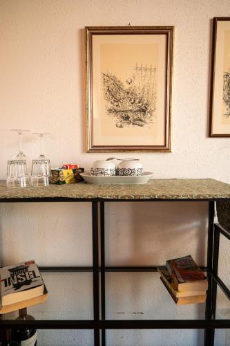 a shelf with a picture on a wall with books at Bernina Express Eco Rooms&Breakfast in Tirano