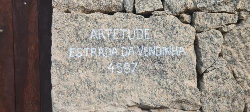 una inscripción en una roca con escritura en ella en Artetude Hostel Cultural, en Barra de Guaratiba