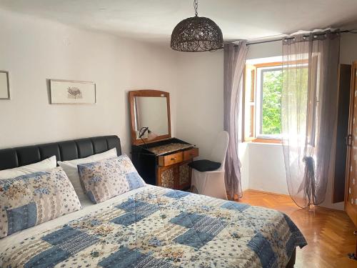 a bedroom with a bed and a mirror and a window at Apartments Luna in Baška
