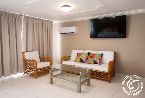 a living room with a couch and chairs and a tv at Hotel Fiesta Mexicana in Manzanillo