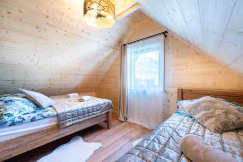 a bedroom with two beds in a log cabin at Karkonoski Klimat - domek z bali in Miłków